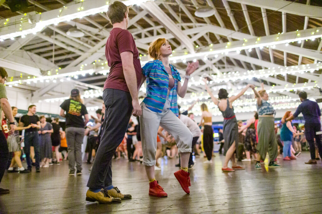 Dancing couple, one posing with heel raised and the other leaning forward into them at Glen Echo Bumper Car Pavilion